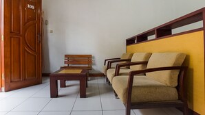 A room with a wooden door labeled 109, a sofa, a bench, and a small table.