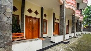 A building with stone walls, wooden doors, and a paved entrance area.