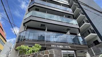 Un hotel moderno con fachada de piedra y varios balcones.