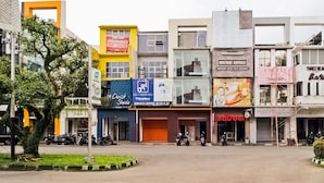 A street view with various storefronts, including a service center and a boutique. - Collection O Kebon Jeruk Near Paskal 23 Formerly Sentral Paskal (Bandung)