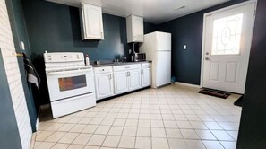 Enjoy cooking in this well-equipped kitchen with a stove and white cabinetry.