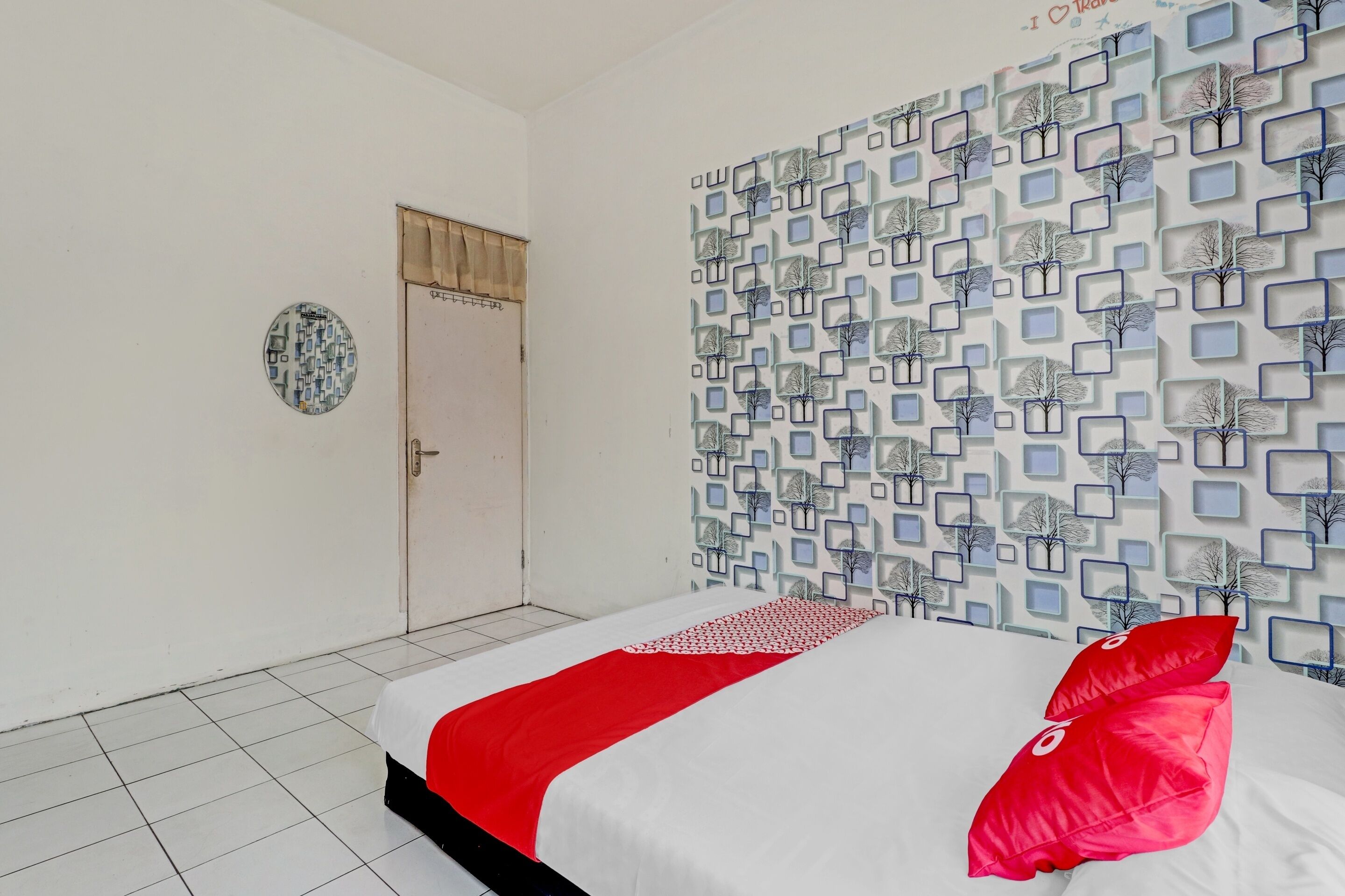 Quarto com cama, porta e parede estampada.