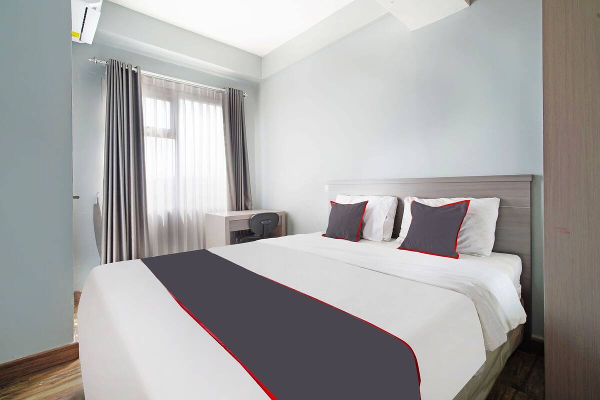 Ein Hotelzimmer mit einem großen Bett, einem Schreibtisch und einem Sessel.