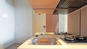 A modern kitchen with a stainless steel sink, a gas stove, and a wooden countertop. - Collection O 91566 Edurent Bandung (Cileunyi)