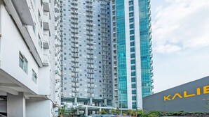 A modern high-rise building with multiple balconies and a glass facade. - Collection O 91566 Edurent Bandung (Cileunyi)