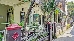 Un immeuble résidentiel doté d’un toit végétalisé, d’une décoration florale rouge sur le portail et d’une enseigne indiquant qu’il s’agit d’un complexe d’appartements comprenant 54 logements.