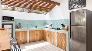 A compact kitchen with wooden cabinets, a stainless steel refrigerator, a microwave, and a coffee maker. - Spacious 3BR Villa W/ Garden & Pool in Bali, Bali Villa 2208 (Seminyak)