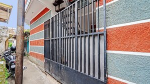 A narrow alley with a metal gate and a motorcycle parked on the left.