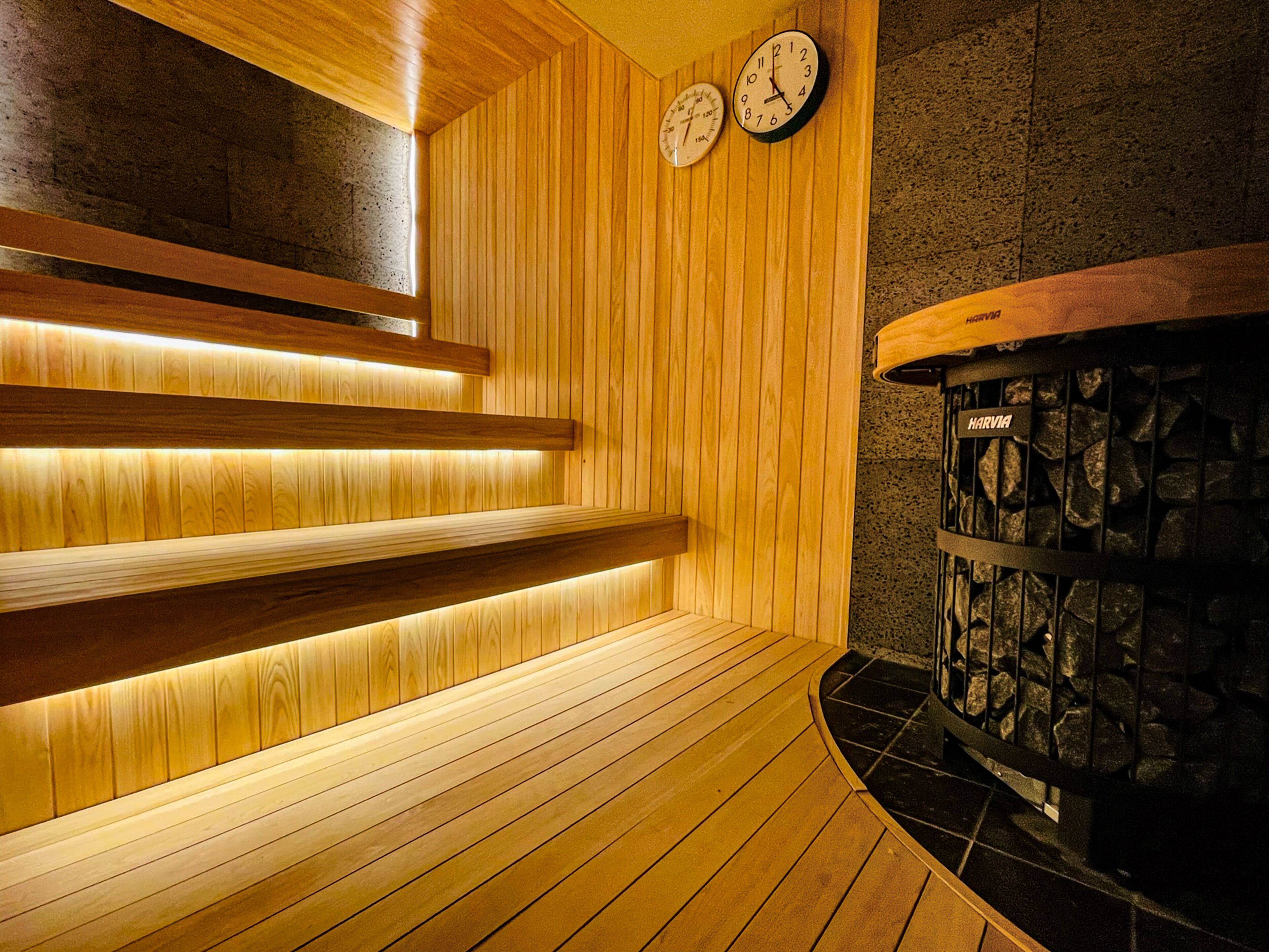 Uma sauna com bancos de madeira e uma parede de pedra.