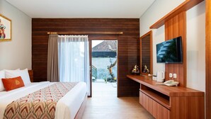 Une chambre d’hôtel avec un lit, une télévision, un bureau en bois et un balcon avec vue.