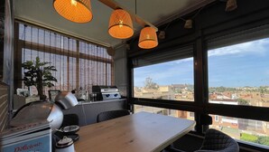 A modern kitchen with a large window, a coffee machine, and a table with chairs.