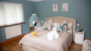 A bedroom with a bed, bedside table, and a window with blinds.