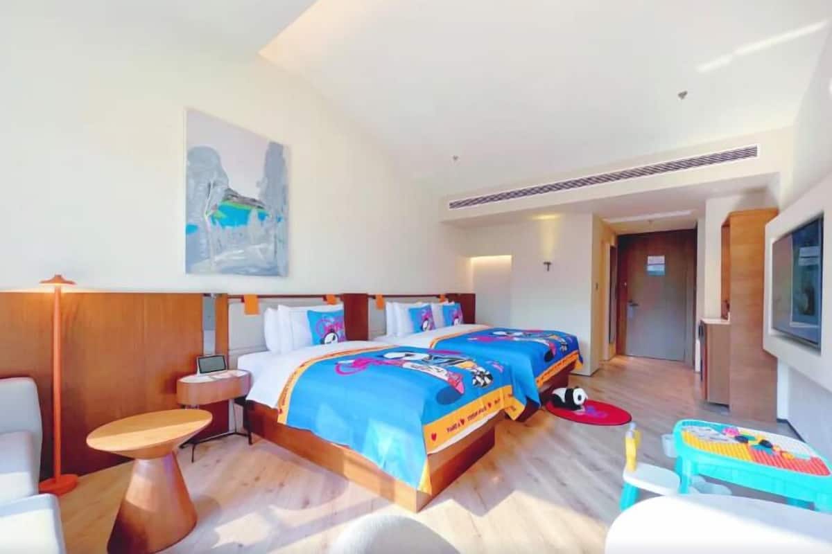 Une chambre d’hôtel avec un grand lit, un bureau, une chaise et un téléviseur.