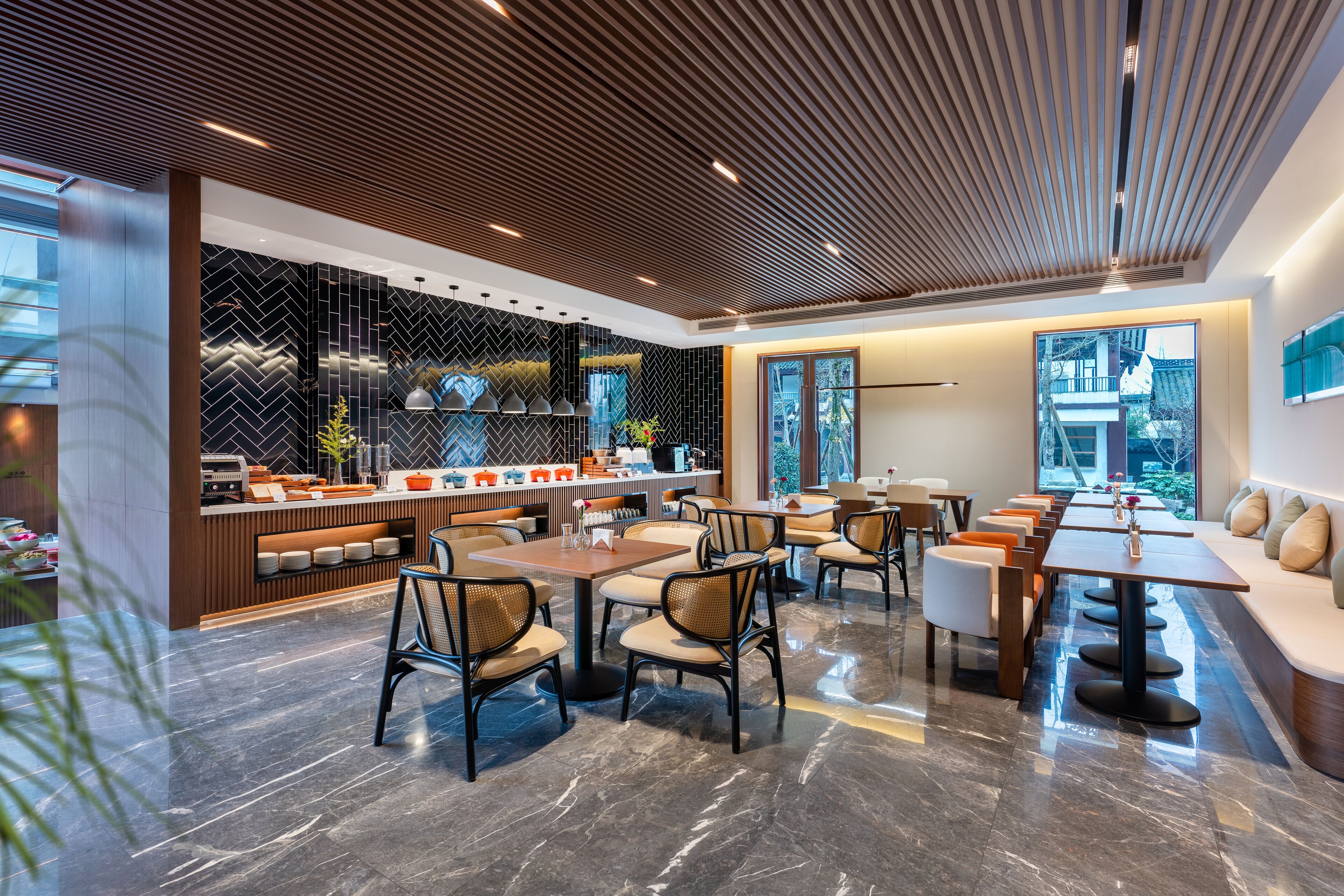 Un restaurante moderno con una larga mesa común, mesas individuales y una zona de bar.