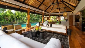 A spacious living area with a pool, wooden furniture, and a thatched roof. - Cheerful 3BR Villa W/ Pool & Garden, Bali Villa 2213 (Seminyak)