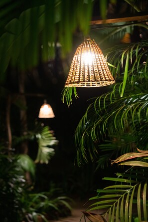 En hängande lampa i en frodig, grön inomhusmiljö.