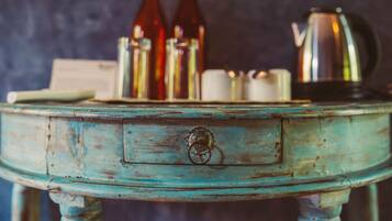 Una mesa rústica color turquesa con diseño vintage, que incluye un cajón y un tirador de metal en forma de anillo.