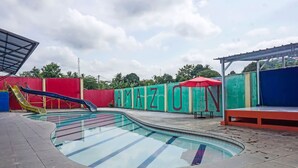 A swimming pool with slides, surrounded by colorful walls with the word "AMAZON" painted on them. - Hotel O Amazon Homestay Syariah 2 (Tjihadak)