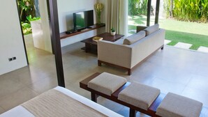 Un salon moderne avec un canapé, une table basse, un téléviseur et une petite plante.