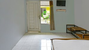 A room with a bed, a TV mounted on the wall, and a window with curtains. - Hotel O Cipto Arum (Cilacap)