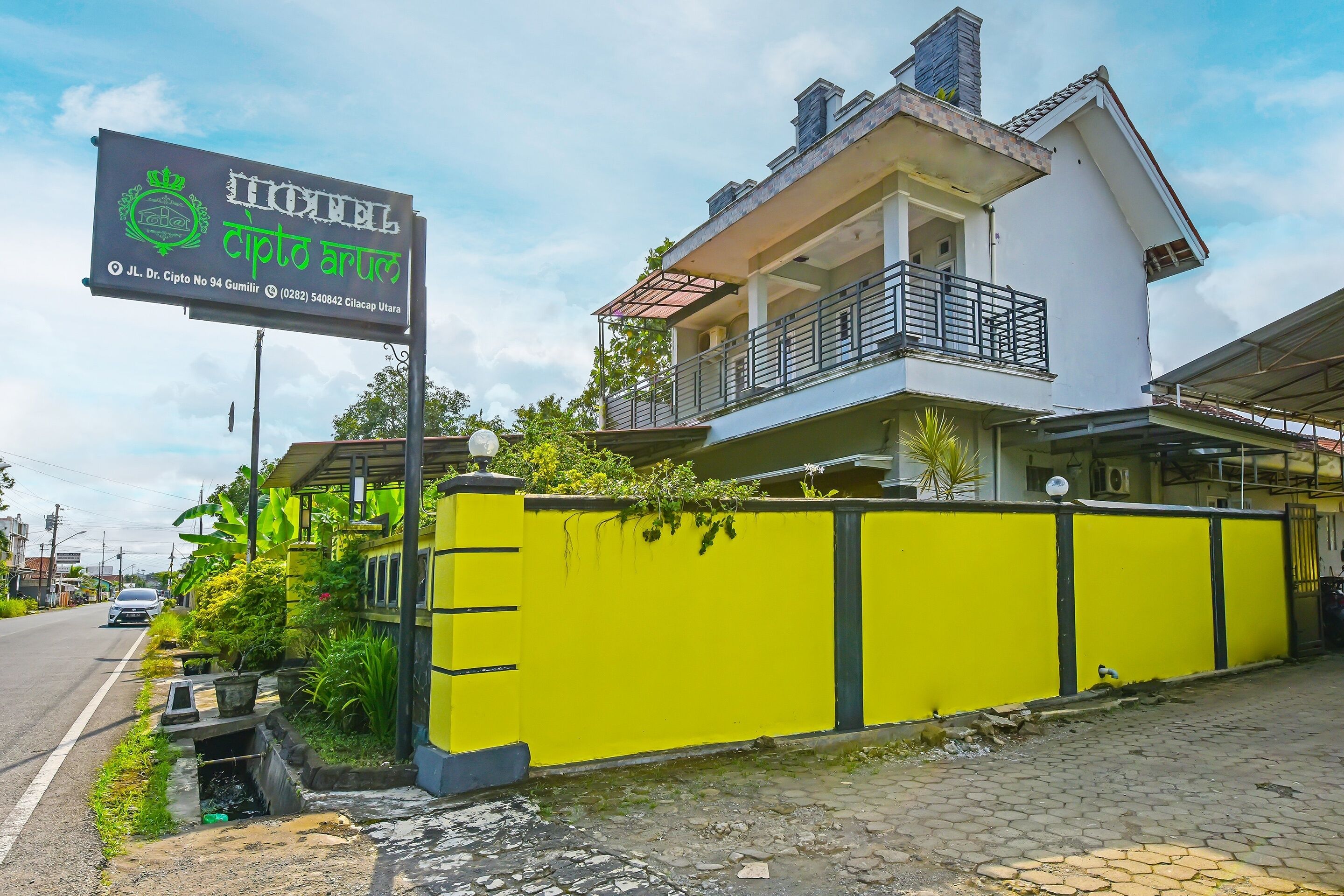 A two-story building with a balcony and a signboard.