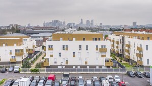 Un edificio residencial de varios pisos con un estacionamiento al frente.
