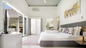 Un dormitorio moderno con una cama grande, un escritorio con computadora, un ventanal amplio y una puerta corrediza de vidrio que da a un balcón.