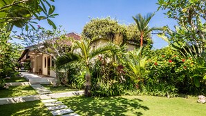 Un jardin avec un sentier menant à un bâtiment.