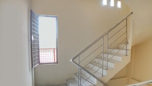 Eine Treppe mit Metallgeländern und einem Fenster mit einem Metallgitter.