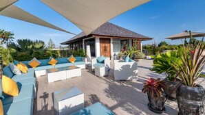 An outdoor seating area with a sofa set, a small table, and potted plants. - Modern 4BR Villa W/ Pool & Balcony, Bali Villa 2220 (Kerobokan)