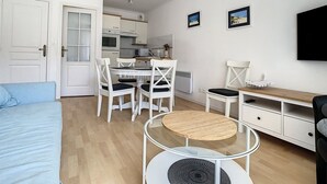 A compact living space with a dining area, kitchenette, and a bed. - Bright Apartment Near Beach with Parking, Balcony & Modern Amenities – Stella (Cucq-Stella Plage)