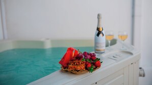 Een zwembadsetting met champagne, glazen en een mand vol fruit.