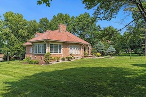 A single-story house with a red-tiled roof, a brick exterior, and a well-maintained lawn. - Beautiful Villa Leocadia+ Private Pool + Sleeps 8! (Kansas City)