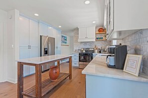 A modern kitchen with white cabinets, a marble countertop, and stainless steel appliances. - Beautiful Villa Leocadia+ Private Pool + Sleeps 8! (Kansas City)