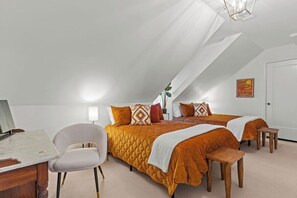 A bedroom with two beds, a desk, and a chair.
