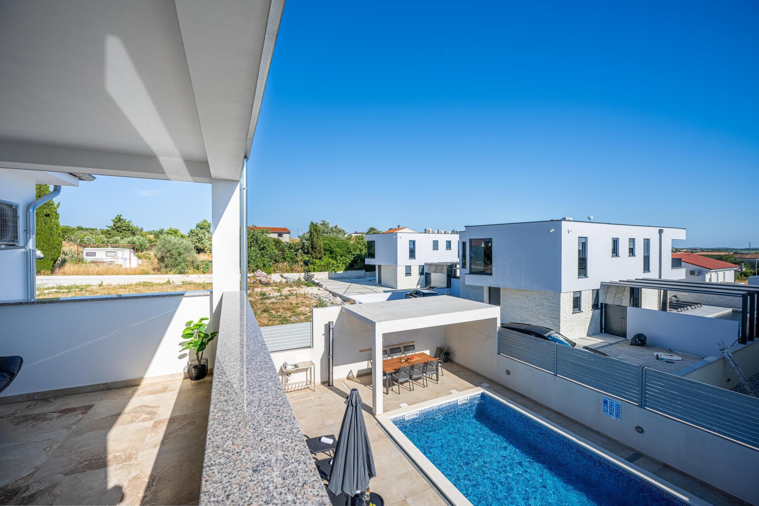 A modern outdoor pool area with a clear view of the surrounding buildings and landscape.