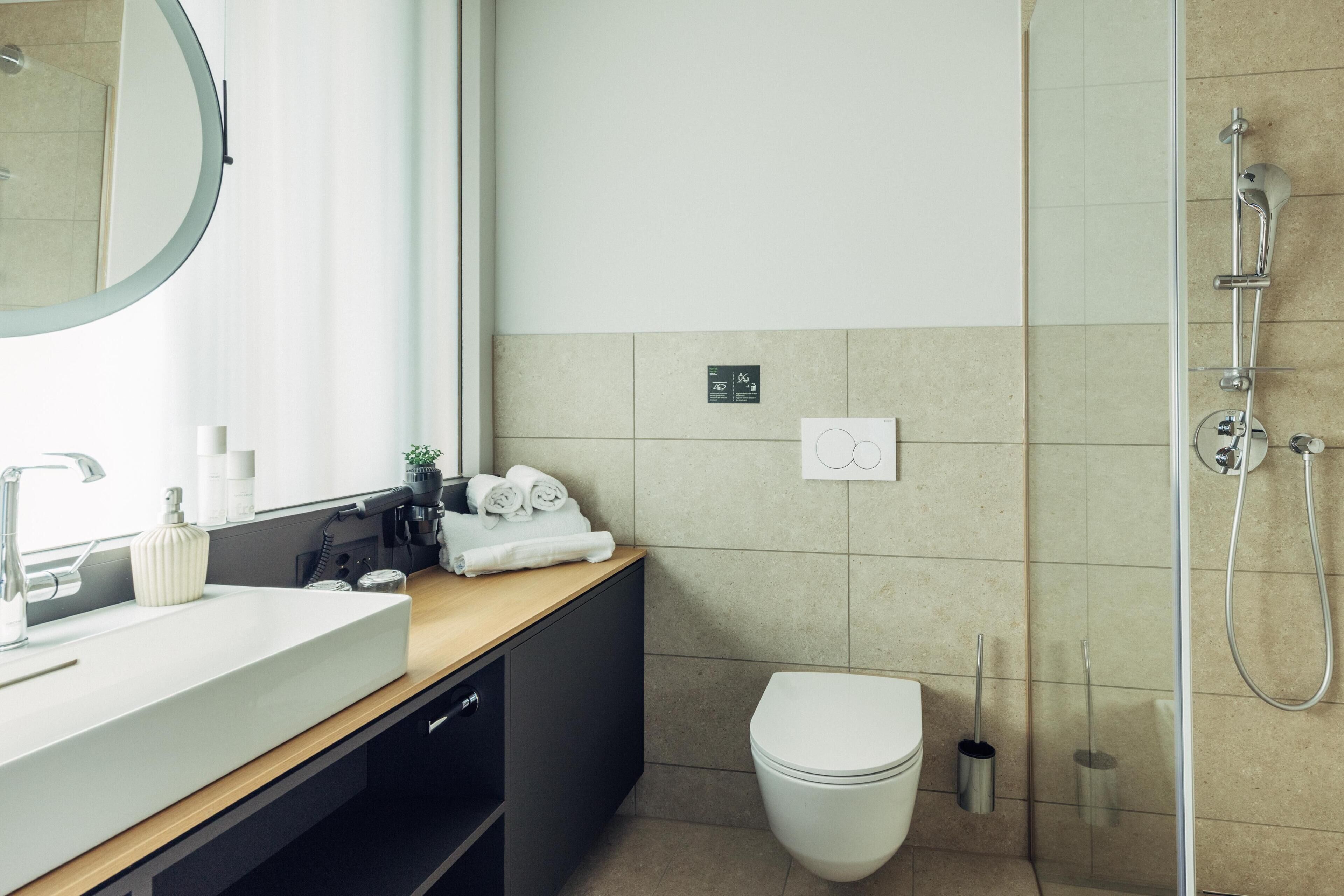 Une salle de bain moderne avec un lavabo, un miroir et une douche.