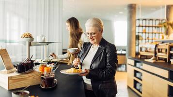 A breakfast setting with a tray of croissants and beverages, a wooden box, and a glass table.