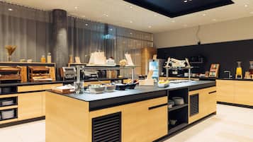 Una cocina moderna con una isla central, armarios de madera y encimera negra.
