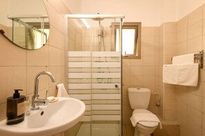 Ein Badezimmer mit Waschbecken, Spiegel, Toilette und Dusche.