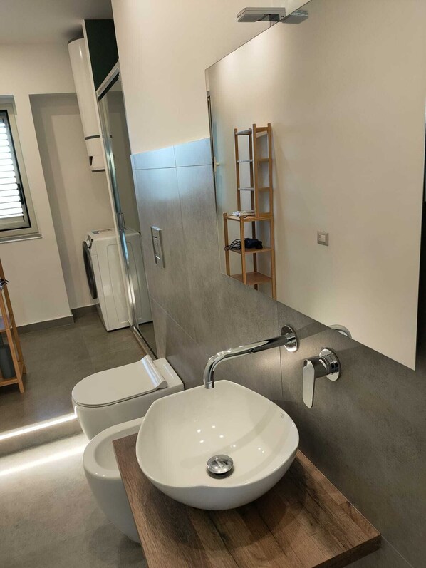 A modern bathroom with a white sink, a toilet, and a shower. - the garden of Etna (Mascalucia)