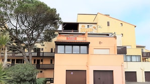 A multi-story building with a flat roof, balconies, and a gated entrance. - Ideal studio near beach and port, sleeps 3 (Capbreton)