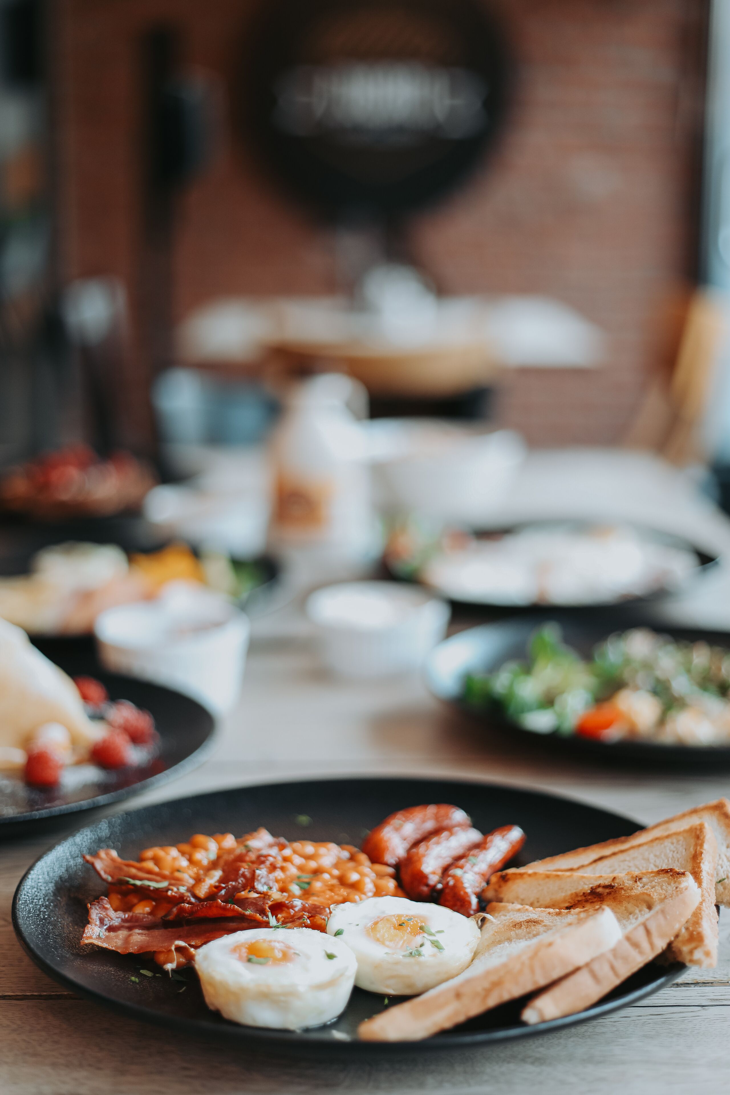 A breakfast spread with various dishes on plates, including eggs, bacon, and toast.