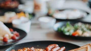 A breakfast spread with various dishes on plates, including eggs, bacon, and toast.