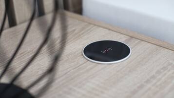 A round, black object with a red symbol on a wooden surface.