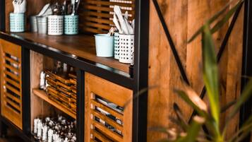 A bar area with wooden shelves, metal containers, and a brick wall.
