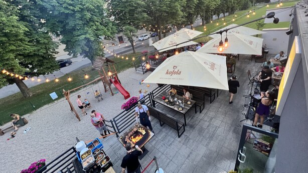An outdoor dining area with tables and chairs, a children's play area, and a food vendor.