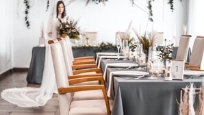 A wedding reception setup with rows of tables, chairs, and floral centerpieces. - Dubno Eat & Sleep (Nova Dubnica)