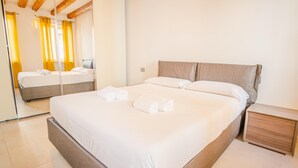 A hotel room with a large bed, a wooden nightstand, and a mirror reflecting the room. - San Giovanni in Valle - Italian Homing (Verona)