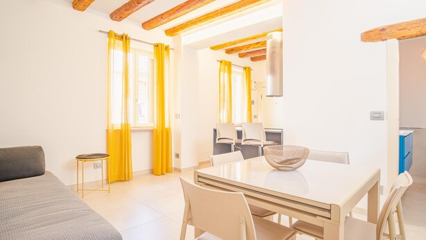 A modern room with a bed, a dining table with chairs, and a kitchen area. - San Giovanni in Valle - Italian Homing (Verona)